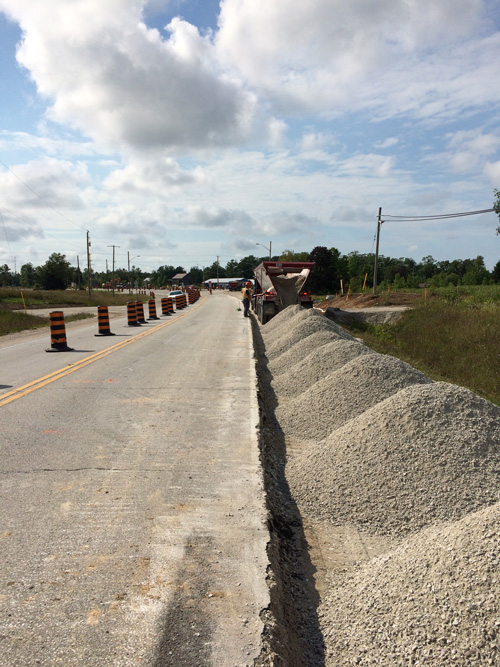 Filling the shoulder of a road with gravel